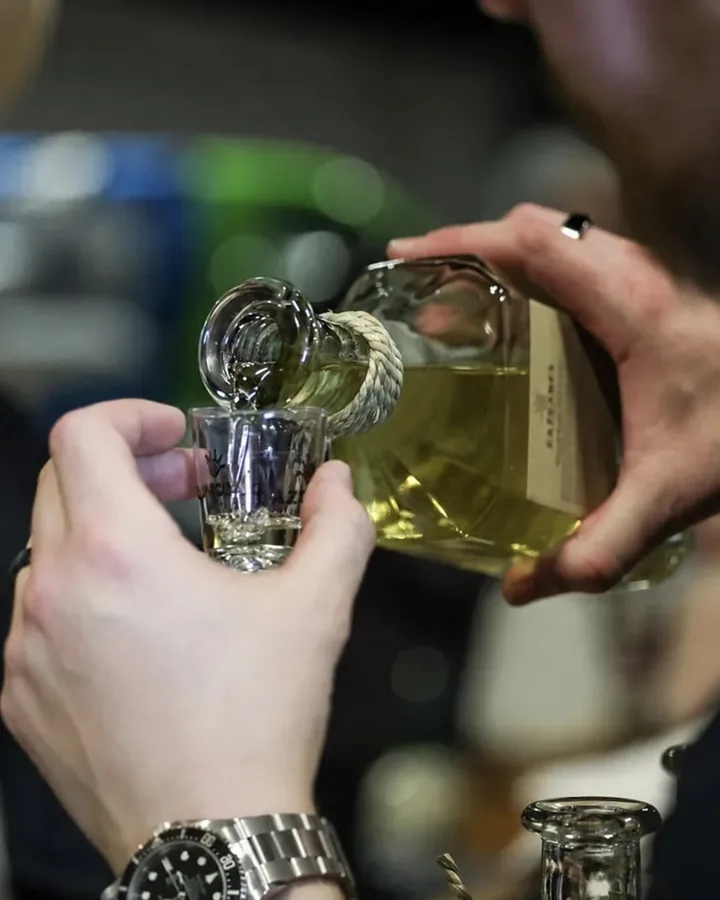 Close-up of tequila being poured into a tasting glass at a past fest