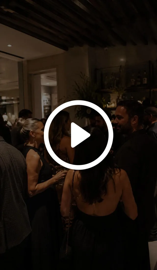 Guests mingling at an upscale evening SoCal Cocktail & Spirits Fest event, with a play button
