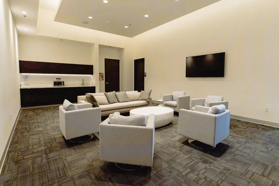 Private lounge with white armchairs arranged in a circle